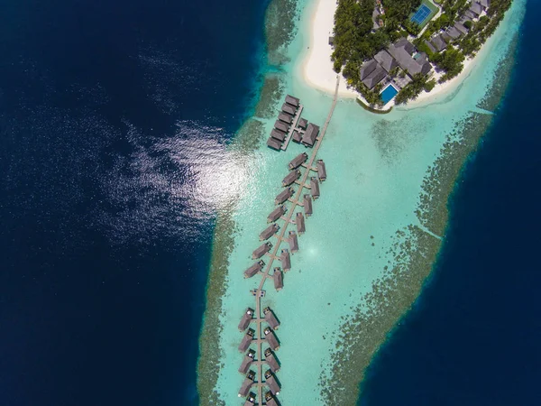 Vista aérea de una isla tropical en aguas turquesas. Lujosas villas sobre el agua en las maldivas del complejo de islas tropicales para vacaciones de vacaciones concepto de fondo - Aumentar el procesamiento de color . — Foto de Stock