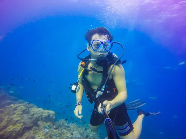 Selfie subacqueo di immersioni con bastone selfie. Mare blu profondo. Colpo grandangolare . — Foto Stock