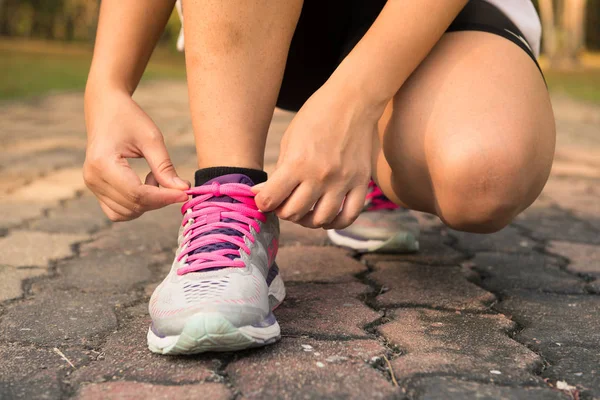 Koşu ayakkabıları - kadın ayakkabı bağcıklarımı bağlıyor. Closeup kadın spor fitness atlet açık havada orman yolu üzerinde geç yaz ya da sonbahar koşu için hazırlanıyor. Vintage etkisi tarzı resimler.