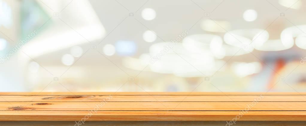 Wooden board empty table blurred background. Perspective brown wood table over blur in department store background, Panoramic banner - can be used mock up for montage products display or design.