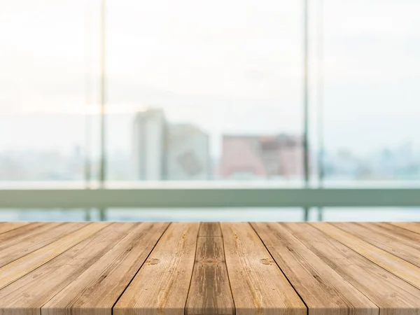 Wooden board empty table top blurred background. Perspective brown wood table over blur city building view background - can be used mock up for montage products display or design key visual layout.