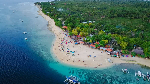 Vista aérea da praia arenosa com turistas nadando na bela água do mar clara da ilha Sumilon aterrissando perto de Oslob, Cebu, Filipinas. - Aumentar o processamento de cores . — Fotografia de Stock