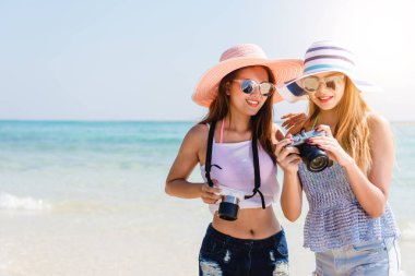 Tropik bir adada tatil zevk Plajı'nda iki serin moda hippi kız mükemmel bronzlaşmış vücudu, sağlıklı cilt, seksi şık rahat kıyafet, bikini, sarışın ve esmer fotoğraf makinesi ile güneş gözlüğü