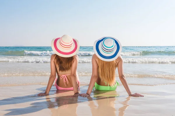 Sexy Bikini-Body asiatische Frauen genießen das Meer, indem sie sich auf den Sand des Strandes legen, mit Melinerie Hut, und beide Beine in der Luft. glücklicher Insellebensstil. weißer Sand und kristallklares Meer am tropischen Strand. — Stockfoto