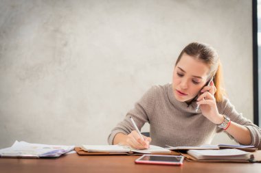 Cep telefonu üzerinde konuşurken ve serbest zaman sırasında kafede tek başına oturmak ve tablet bilgisayarda çalışma sırasında gülümseyen genç çekici kız. Mutlu erkek dinlenme kafede sahip. Yaşam tarzı.