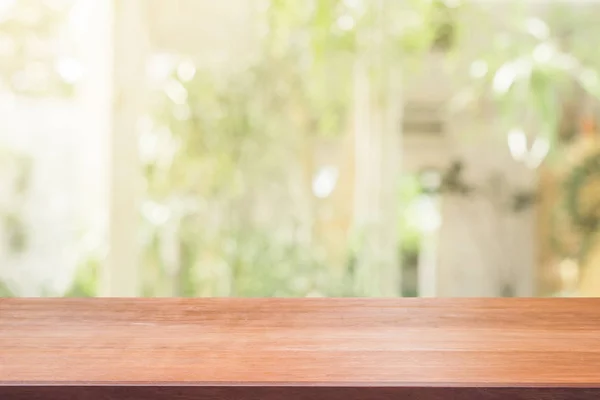 Tablero de madera mesa vacía sobre fondo borroso. Mesa de madera marrón perspectiva sobre desenfoque en el fondo de la cafetería - se puede utilizar la maqueta para la exhibición de productos de montaje o diseño diseño diseño visual clave. — Foto de Stock