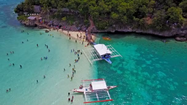 Aerial view flying over amazing of sandy beach with tourists swimming in beautiful clear sea water of the Sumilon island beach landing near Oslob, Cebu, Philippines. — Stock Video