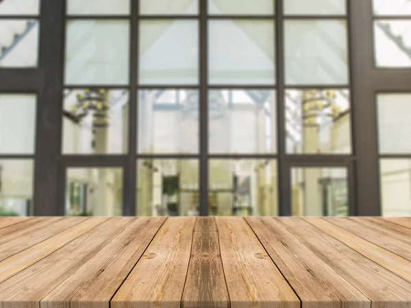 Tablero de madera mesa vacía sobre fondo borroso. Mesa de madera marrón perspectiva sobre desenfoque en el fondo de la cafetería - se puede utilizar la maqueta para la exhibición de productos de montaje o diseño diseño diseño visual clave. —  Fotos de Stock