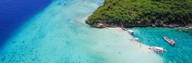 Aerial view of sandy beach with tourists swimming in beautiful clear sea water of the Sumilon island beach landing near Oslob, Cebu, Philippines. - Boost up color Processing. Panoramic banner. clipart