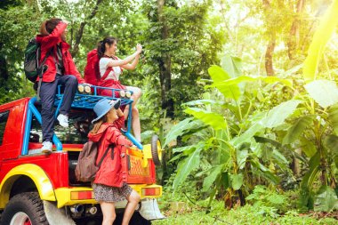 Ormandaki mutlu Asya genç gezginler 4wd sürücü araba yoldan ile harita ve başka bir yön arayan genç bir çift iki 4wd sürücü araba tadını çıkarıyor. Genç yarış Asyalı kadın ve erkek karışık.