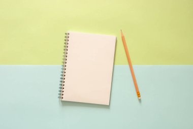 En az çalışma alanı - yaratıcı düz fotoğraf çalışma masası sketchbook ve ahşap kalem kopya alanı yeşilin ve mavinin pastel zemin üzerine yatırın. Üstten Görünüm, düz yatıyordu fotoğraf.