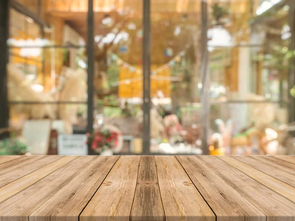 Tablero de madera mesa vacía sobre fondo borroso. Mesa de madera marrón perspectiva sobre desenfoque en el fondo de la cafetería - se puede utilizar la maqueta para la exhibición de productos de montaje o diseño diseño diseño visual clave. — Foto de Stock