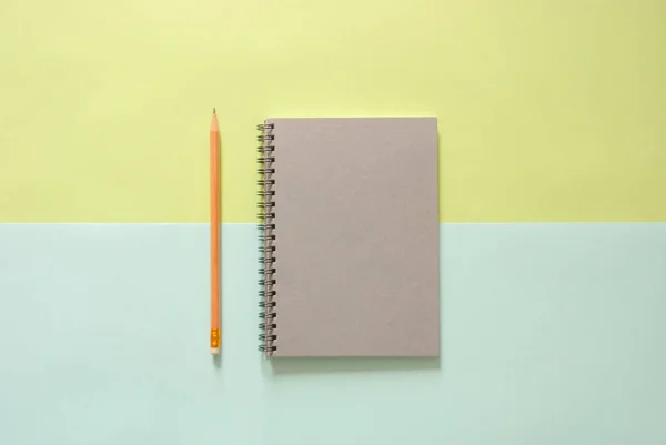 Minimal work space - Creative flat lay photo of workspace desk with sketchbook and wooden pencil on copy space green and blue pastel background. Top view , flat lay photography.