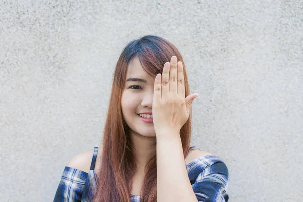 Smilende ung, vakker asiatisk kvinne som lukker øynene med hendene på betongveggens bakgrunn. Bilder av årgangseffekt . – stockfoto