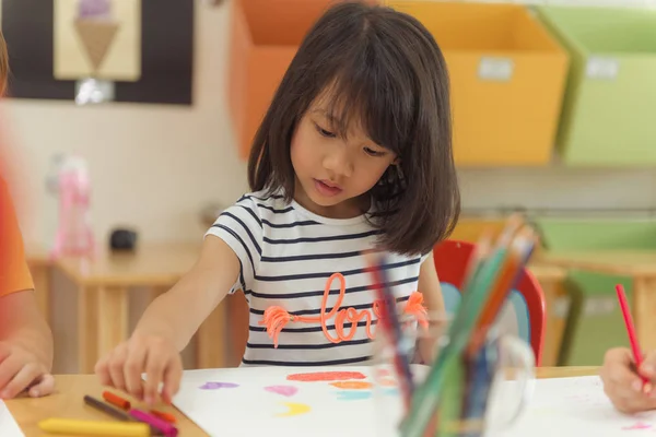 Girl drawing color pencils in kindergarten classroom, preschool and kid education concept, Vintage effect style pictures. — Stock Photo, Image