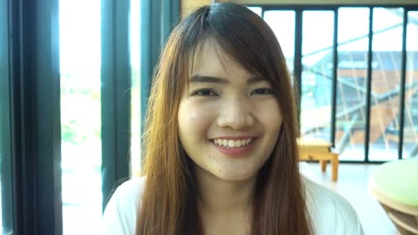 Retrato de sonriente hermosa asiática estudiante de pie en la biblioteca . — Vídeo de stock