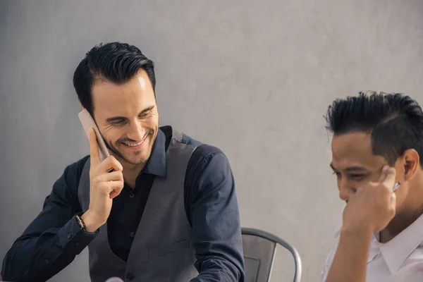 Proyecto exitoso. Dos personas de negocios alegres en ropa formal discutiendo algo y sonriendo mientras uno de ellos apunta tableta digital — Foto de Stock
