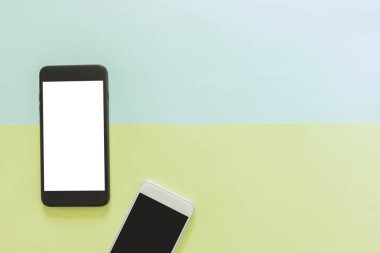En az çalışma alanı - yaratıcı düz çalışma masası cep telefonu ile fotoğraf kopyalama alanı yeşilin ve mavinin pastel arka plan boş ekran yatırın. Üstten Görünüm, düz yatıyordu fotoğraf alay.