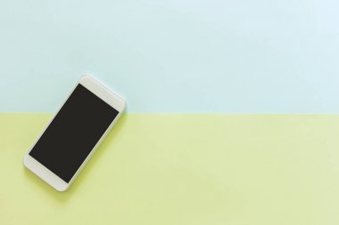 En az çalışma alanı - yaratıcı düz çalışma masası cep telefonu ile fotoğraf kopyalama alanı yeşilin ve mavinin pastel arka plan boş ekran yatırın. Üstten Görünüm, düz yatıyordu fotoğraf alay.