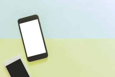 En az çalışma alanı - yaratıcı düz çalışma masası cep telefonu ile fotoğraf kopyalama alanı yeşilin ve mavinin pastel arka plan boş ekran yatırın. Üstten Görünüm, düz yatıyordu fotoğraf alay.