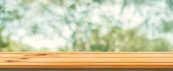 Wooden board empty table blurred background. Perspective brown wood table over blur trees forest background - can be used mock up for display or montage your products. spring season. panoramic banner.