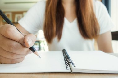 Kız öğrenci Kütüphanesi'nde bir kitaptan not alma. Genç Asyalı kadın kolej kütüphane atamaları yapmak masada oturuyor. Vintage etkisi tarzı resimler.