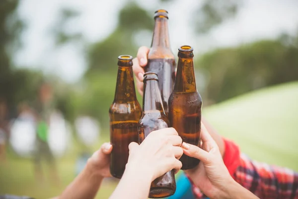 Bottles of beer.Group of friends enjoying party.people are drinking beer and laughing . The guy plays the guitar. Everyone has a great mood. Summer time. Vintage effect style pictures.