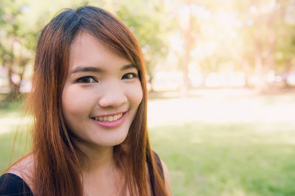 Gözleri kapalı, canlı, nefes, rüya hissettiriyor rahatlatıcı sakin güzel gülümseyen genç kadınla temiz hava açık, zevk at kuyruğu. Alanı, yeşil park doğa arka plan kopyalayın. Yan görünüm portre