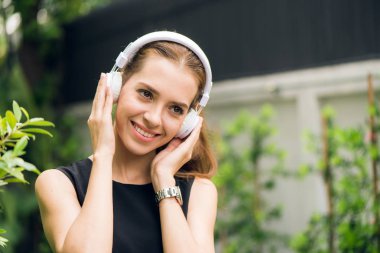 İnsanlar eğlence ve teknoloji kavramı - açık havada müzik çalar müzik dinlerken çekici genç kadın. Hippi kız sabah parkta onun kulaklık müzik zevk. Mercek parlaması.