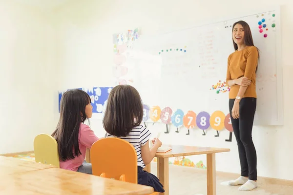 Pendidikan, sekolah dasar, pembelajaran dan konsep masyarakat - sekelompok anak-anak sekolah dengan guru duduk di kelas. Gaya gambar efek vintage . — Stok Foto