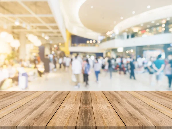 木の板の空のテーブルには、ショッピング モールの背景がぼやけています。デパート バック グラウンドで - 茶色の視点木製テーブル ブレは、表示に使用することができますやモンタージュの製品。製品のために模擬します。 — ストック写真