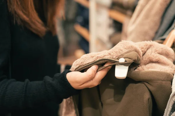 Half body shot di una giovane donna asiatica felice con borsa a tracolla che guarda i vestiti appesi sulla rotaia all'interno del negozio di abbigliamento. Shopping, moda, stile e persone concetto di donna . — Foto Stock