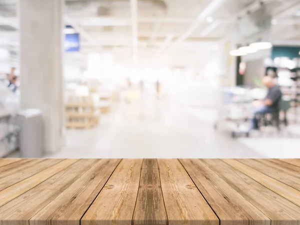 Drewniana deska pustą tabela niewyraźne tło centrum handlowego. Perspektywy brązowy drewniany stół rozmycie w tle dom towarowy - może służyć do wyświetlania lub montaż produktów. Mock up dla produktu — Zdjęcie stockowe