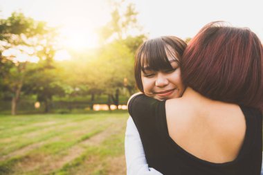 LGBT lezbiyen kadınlar çift anlar mutluluk. Lezbiyen kadınlar çift birlikte açık havada kavramı. Lezbiyen çift kucakladı birlikte ilişkisi aşık. Eğlenceli birlikte park adlı iki Asyalı kadın.