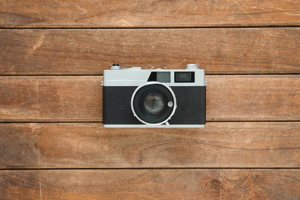 Office desk wooden table with old camera. Top view with copy space. Top view of old camera over wooden table. Retro vintage filter. — Stock Photo, Image