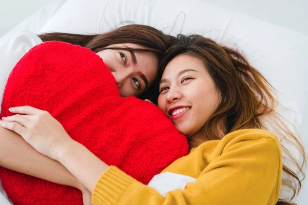 Vue du dessus de belles jeunes femmes asiatiques lesbiennes couple heureux étreignant et souriant tout en étant couché ensemble dans le lit sous couverture à la maison. Des femmes drôles après le réveil. Couple lesbien ensemble concept intérieur . — Photo