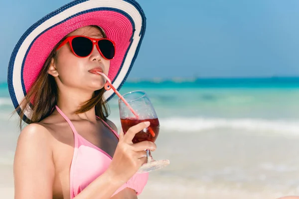 Stile di vita felice giovane donna asiatica adulta in bikini rosa con cocktail in mano e cappello di paglia sulla spiaggia. Stile di vita all'aperto ritratto donna. Stile di vita donna concetto estivo . — Foto Stock