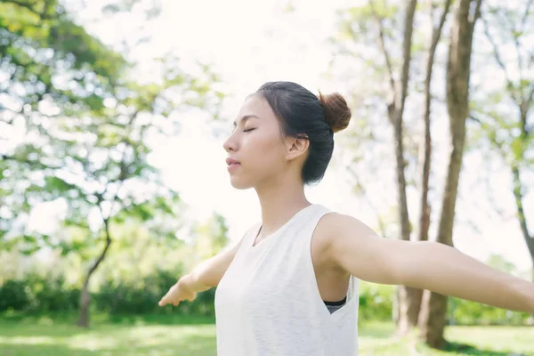 Junge asiatische Frau Yoga im Freien Ruhe bewahren und meditiert, während sie Yoga praktiziert, um den inneren Frieden zu erkunden. Yoga und Meditation haben einen guten Nutzen für die Gesundheit. Yoga-Sport und gesundes Lebensstil-Konzept. — Stockfoto