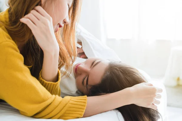 Mooie jonge Aziatische vrouwen Lgbt lesbische gelukkige paar knuffelen en glimlachen terwijl liggen samen in bed onder de deken thuis. Grappige vrouwen na wakker worden. LGBT lesbisch koppel samen binnenshuis concept. — Stockfoto