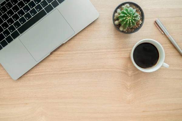 Minimal work space - Creative flat lay photo of workspace desk. Top view office desk with laptop, plant, coffee cup copy space on wooden background. Top view with copy space, flat lay photography.