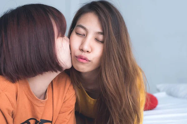 Belles jeunes femmes asiatiques LGBT lesbienne couple heureux assis sur le lit étreignant et souriant ensemble dans la chambre à coucher à la maison. LGBT couple lesbien ensemble concept intérieur. Passer du bon temps à la maison . — Photo