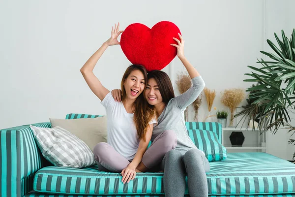 Pasangan lesbian muda Asia yang cantik pasangan LGBT duduk di sofa berpelukan dan tersenyum bersama di ruang tamu di rumah. LGBT lesbian pasangan bersama-sama dalam ruangan konsep. Menghabiskan waktu yang baik di rumah . — Stok Foto