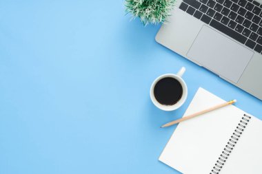 En az çalışma alanı - yaratıcı düz fotoğraf çalışma masası yatıyordu. Üstten Görünüm ofis büro dizüstü bilgisayar, dizüstü bilgisayarlar ve mavi renk arka plan üzerinde kahve fincanı. Kopya alanı, düz yatıyordu fotoğraf ile Üstten Görünüm.