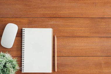 En az çalışma alanı - yaratıcı düz fotoğraf çalışma masası yatıyordu. Defter ve kalem ve bitki açık sahte ile ofis Resepsiyon ahşap masa arka plan. Kopya alanı, düz yatıyordu fotoğraf ile Üstten Görünüm.