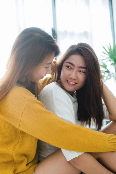 Hermosas mujeres asiáticas jóvenes LGBT lesbianas feliz pareja sentada en la cama abrazando y sonriendo juntos en el dormitorio en casa. LGBT pareja de lesbianas juntos en el interior del concepto. Pasar un buen tiempo en casa . —  Fotos de Stock