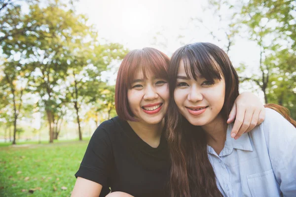Dwóch przyjaciół piękny szczęśliwy młodych Azjatek, wspólna zabawa w parku i biorąc selfie. Hipster szczęśliwe młode Azjatki uśmiechając się i patrząc na kamery. Pojęcia dotyczące stylu życia i przyjaźni. — Zdjęcie stockowe