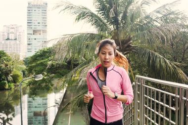 Kaldırımda sabah çalışan genç Asyalı kadın. Genç Asyalı kadın şehir merdivenlerde yukarı çalışan spor. Fitness Spor insanlar ve sağlıklı yaşam konsepti.