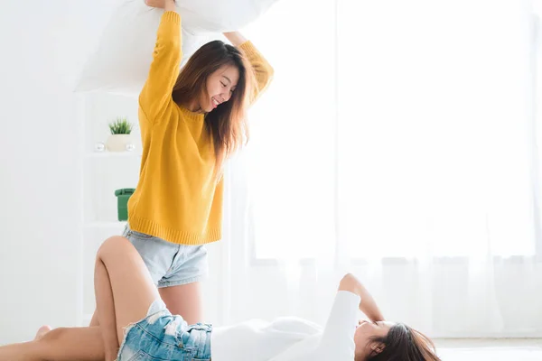 Pasangan lesbian muda Asia bermain satu sama lain dengan momen cinta di tempat tidur di kamar tidur dikelilingi dengan sinar matahari hangat. Pasangan LGBT memiliki momen cinta bersama ion tempat tidur. Konsep momen cinta LGBT . — Stok Foto
