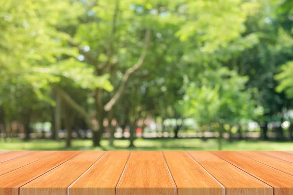 Meja kosong papan kayu di depan latar belakang kabur. Perspektif tabel kayu coklat di atas pohon blur di latar belakang hutan - dapat digunakan tiruan untuk tampilan atau montase produk Anda. musim semi . — Stok Foto