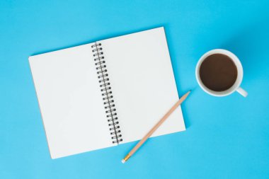 Ofis Masası adlı kullanıcının alanı - düz çalışma üstten görünüm mockup bir çalışma alanı beyaz boş defter sayfası, kahve fincanı ve dekorasyon pastel mavi zemin üzerine yatırın. Pastel mavi renk arka plan boşluk kavramı.
